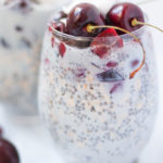 Overnight oats in wine glass topped with fresh cherries.