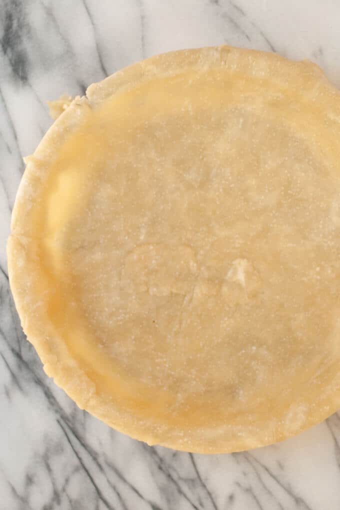 Unbaked pie crust on marble background