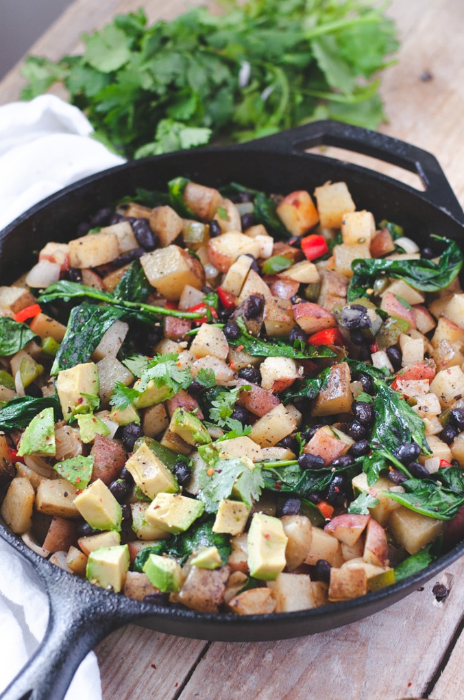 Close up of potato breakfast skillet topped with cilantro and avocado.