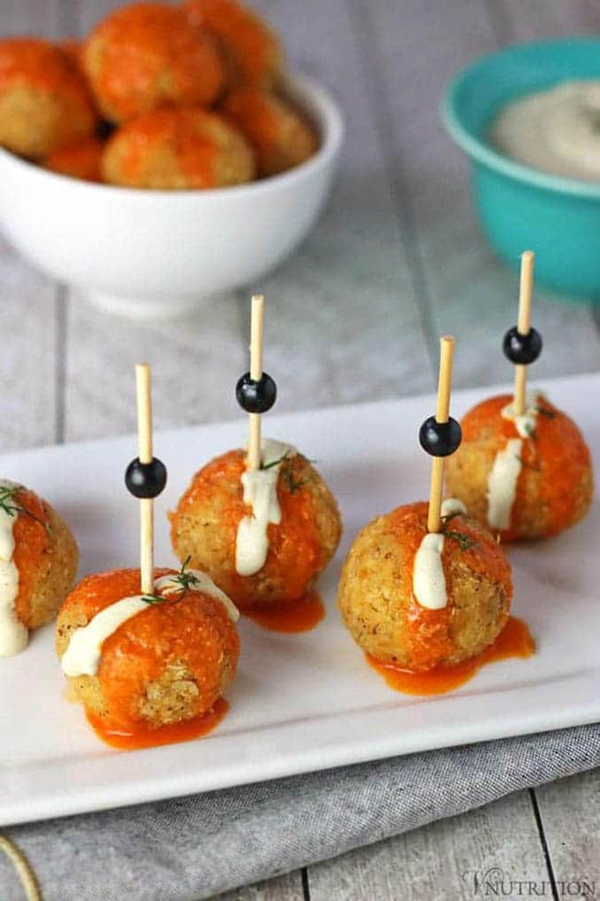 Quinoa balls with toothpicks in them on white platter