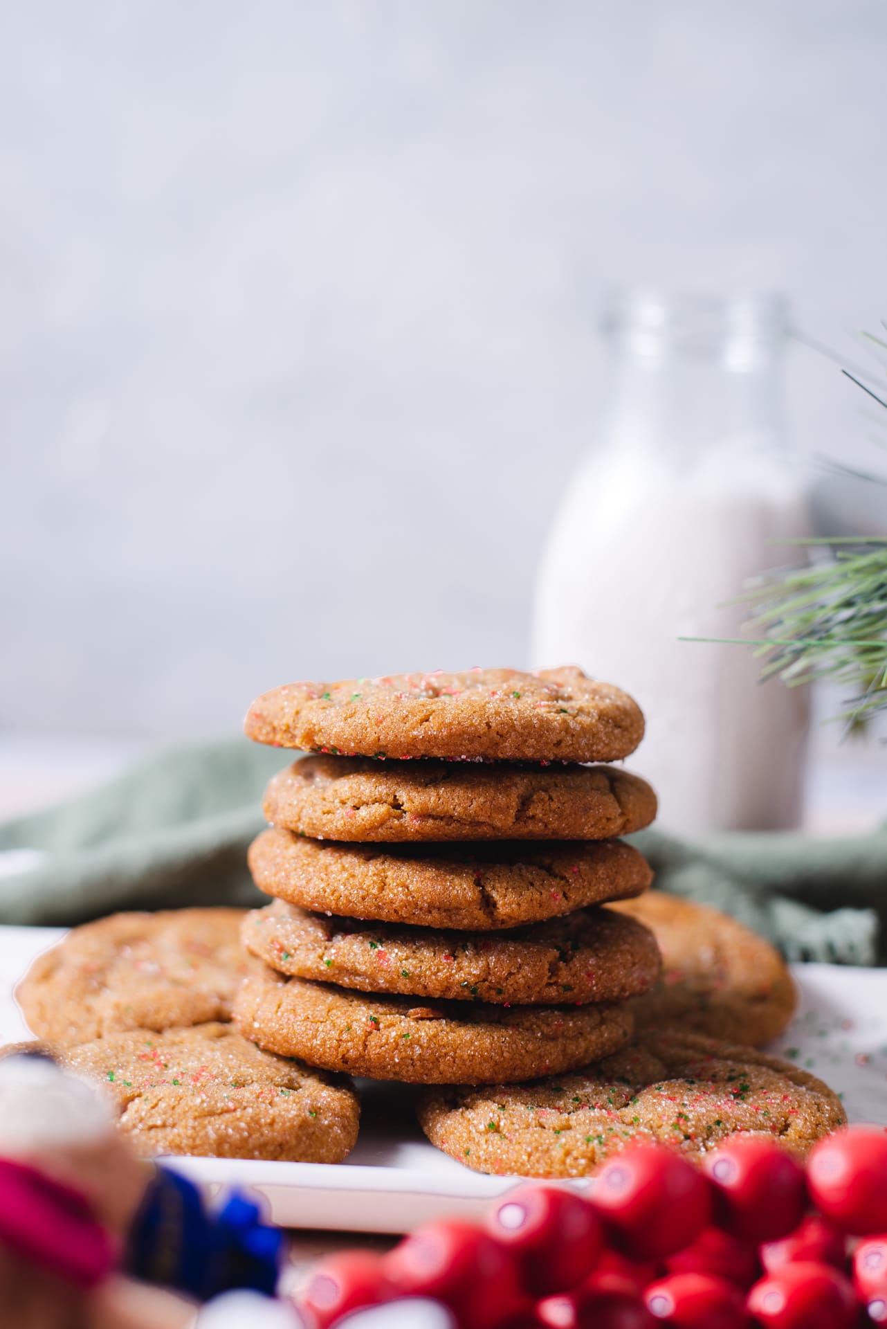 Side view of stack of five cookies with glass of milk in the background
