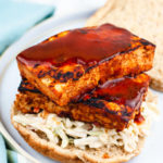 Two slices of bbq tofu on a bed of coleslaw.