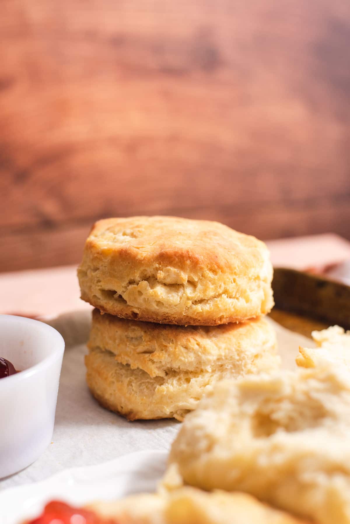 Two biscuits stacked on top of each other with more biscuits in the foreground.