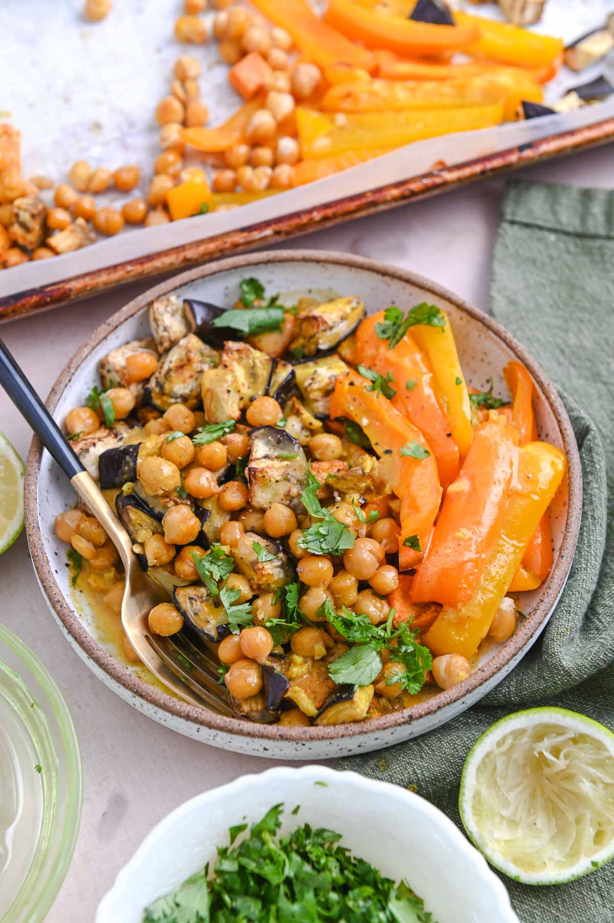 White bowl with chickpeas and roasted vegetables.