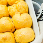Overhead view of eight sweet potato rolls in a white baking dish