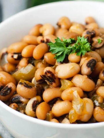 Close up of black eyed peas in a white bowl.