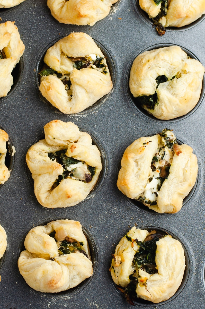 Cooked puff pastry appetizers in a muffin tin.