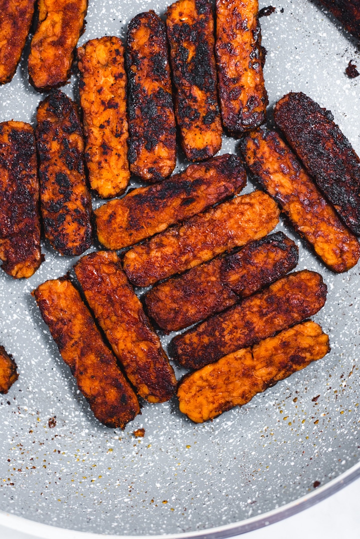 Close up of golden brown tempeh in a gray pan