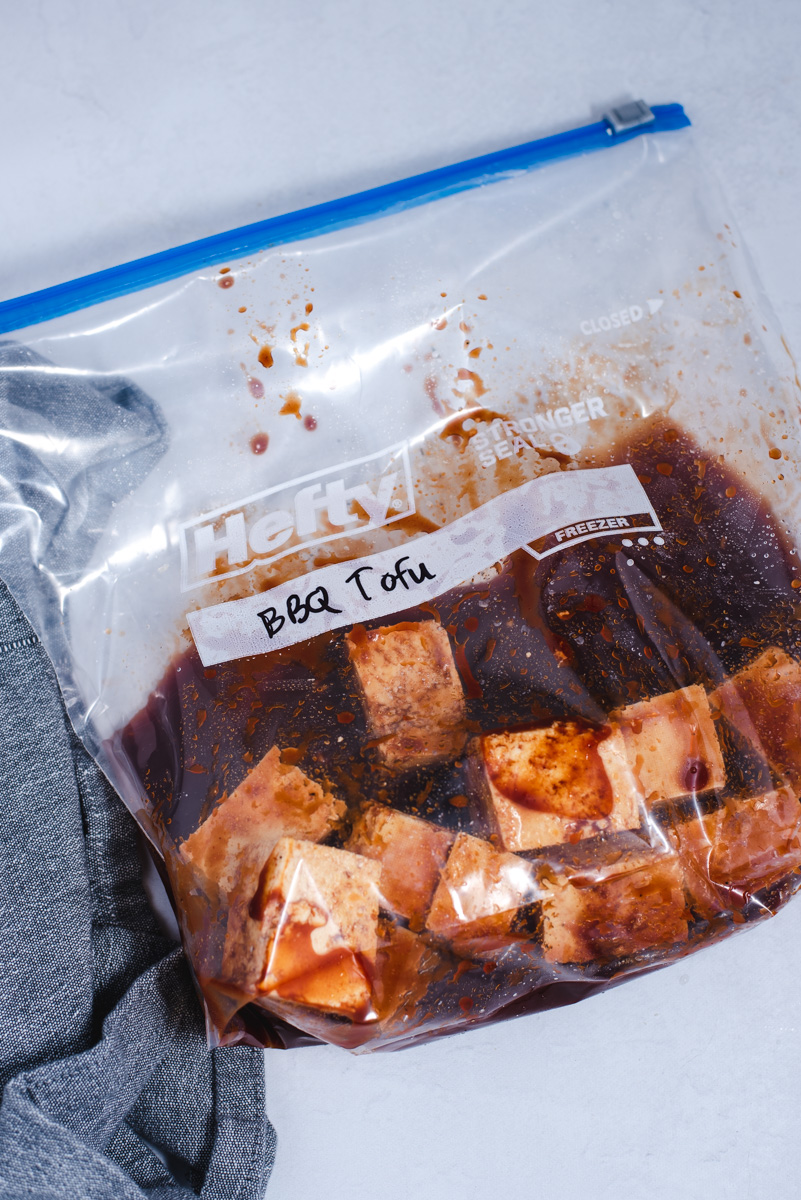 Plastic ziploc bag filled with tofu and barbecue sauce.