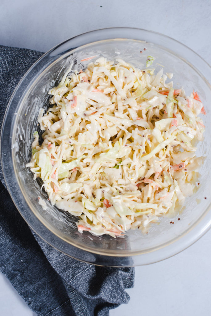 Coleslaw in a glass bowl on a gray background