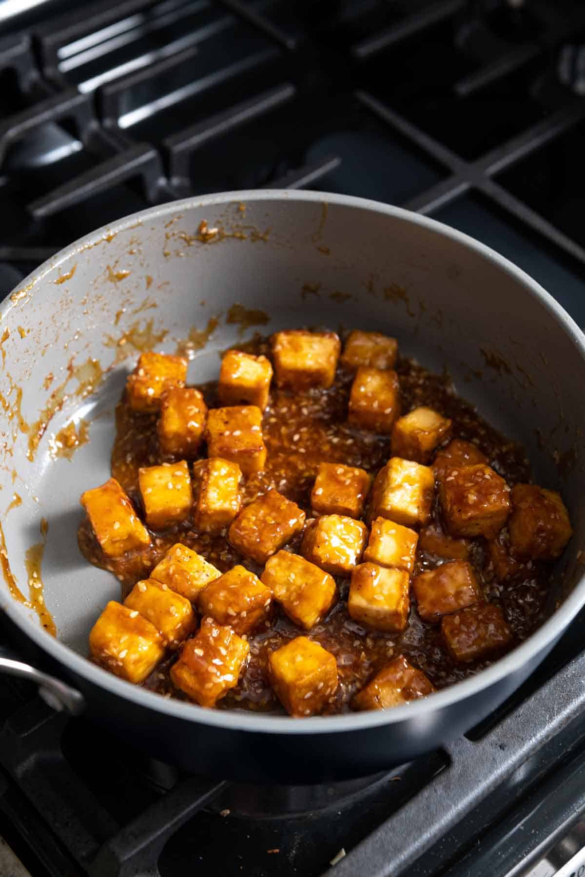 Baked tofu in sesame sauce in a sauce pot.