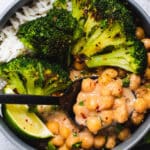 Gray bowl filled with chickpeas, broccoli, rice and a lime wedge