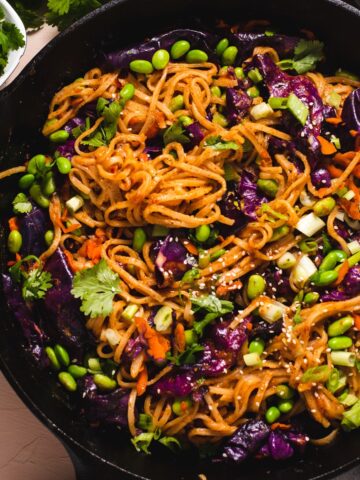 Black cast iron pan filled with almond butter stir fry.