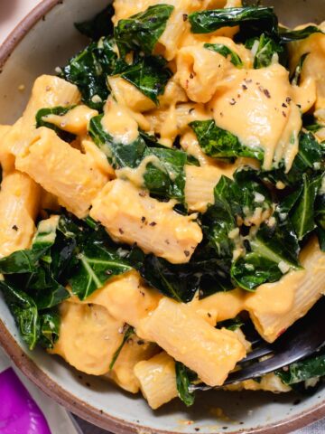 Bowl of butternut squash mac and cheese with collard greens.