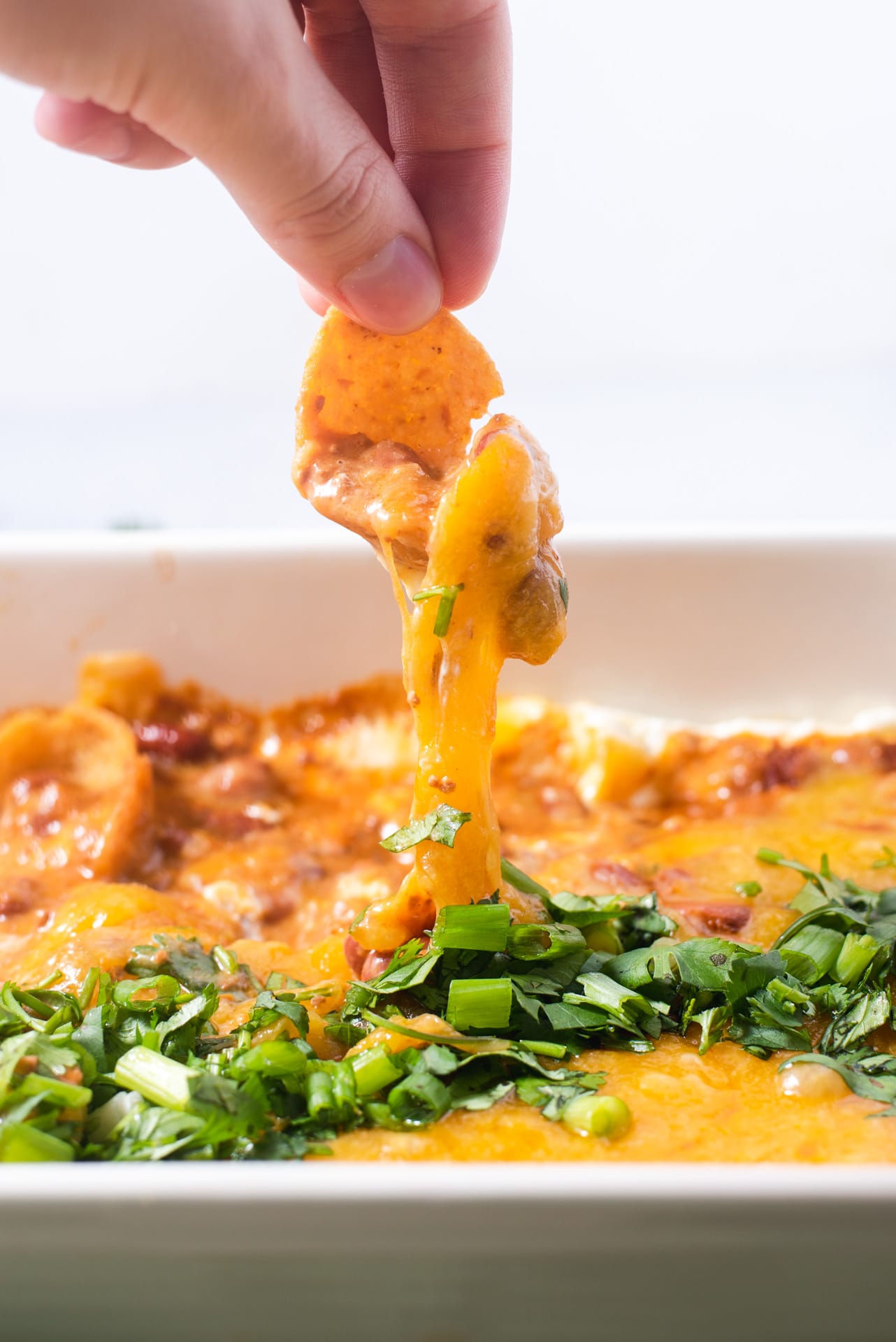 Frito pulling cheese from casserole dish