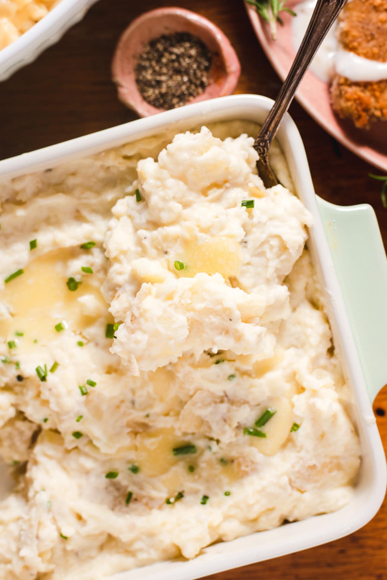 Mashed potatoes topped with butter and chives.