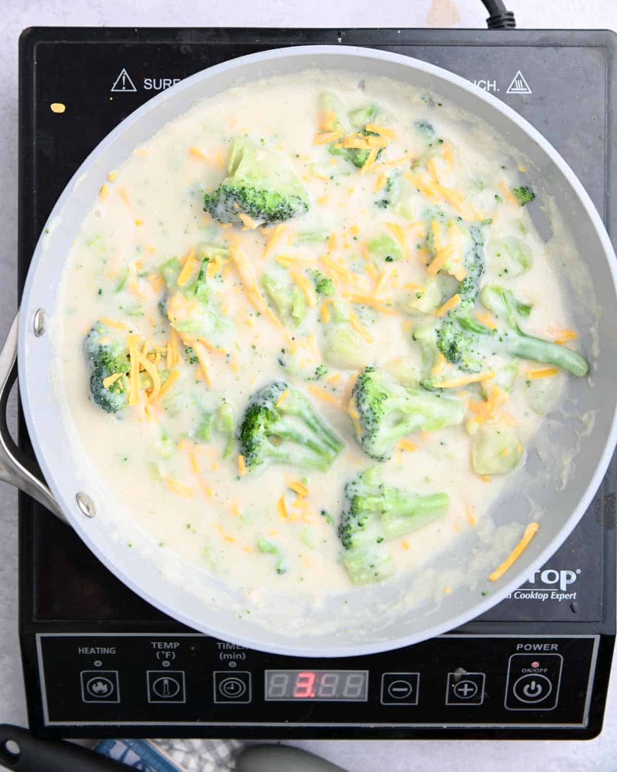 Broccoli cheddar filling in a gray skillet.
