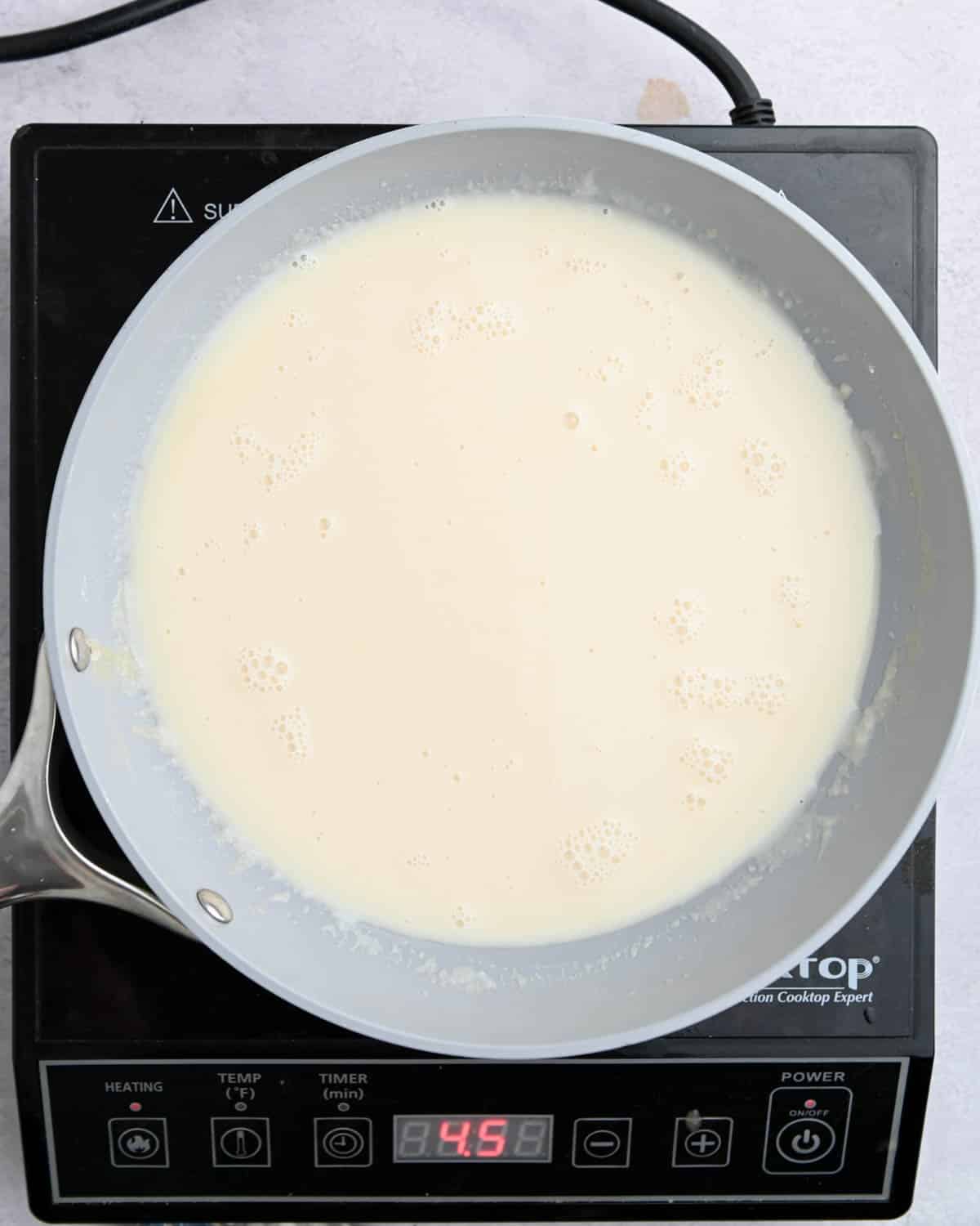 Creamy sauce in a gray skillet.