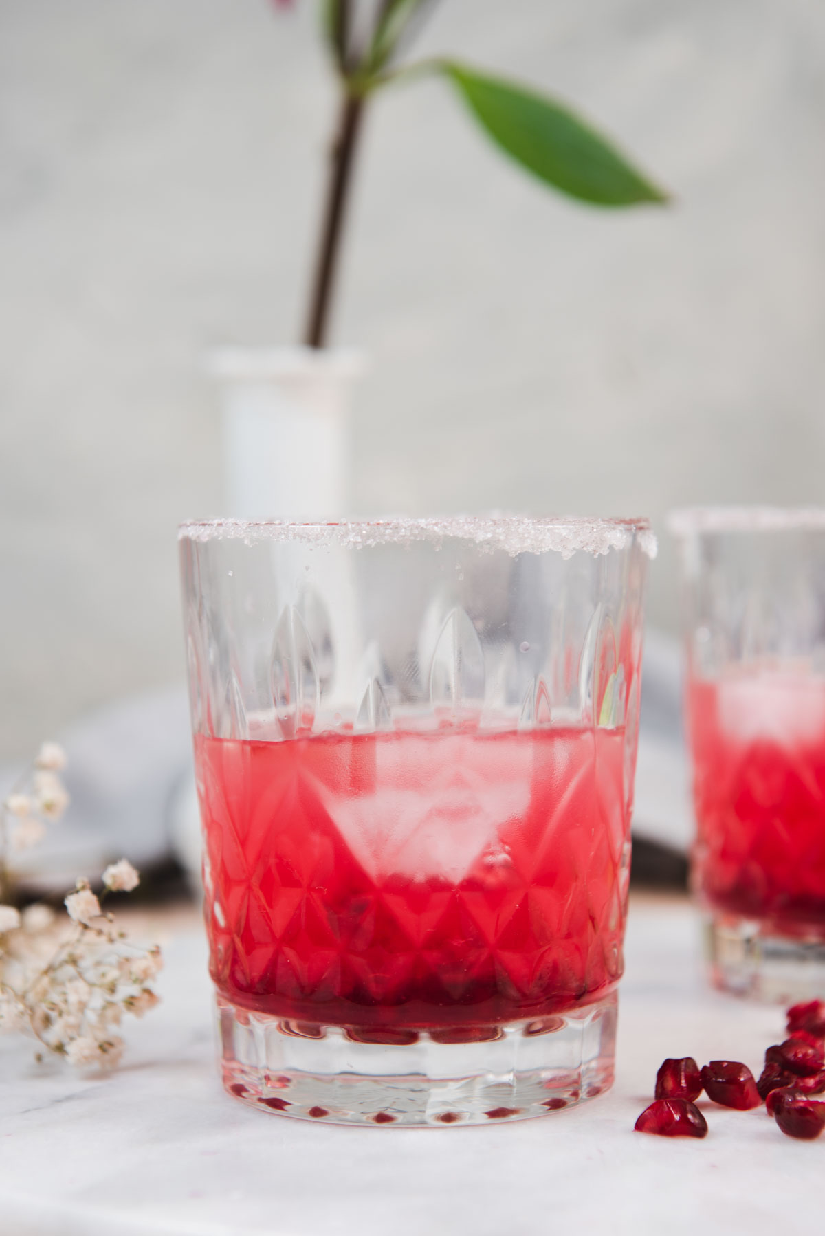 Pink cocktail in a sugar rimmed glass.