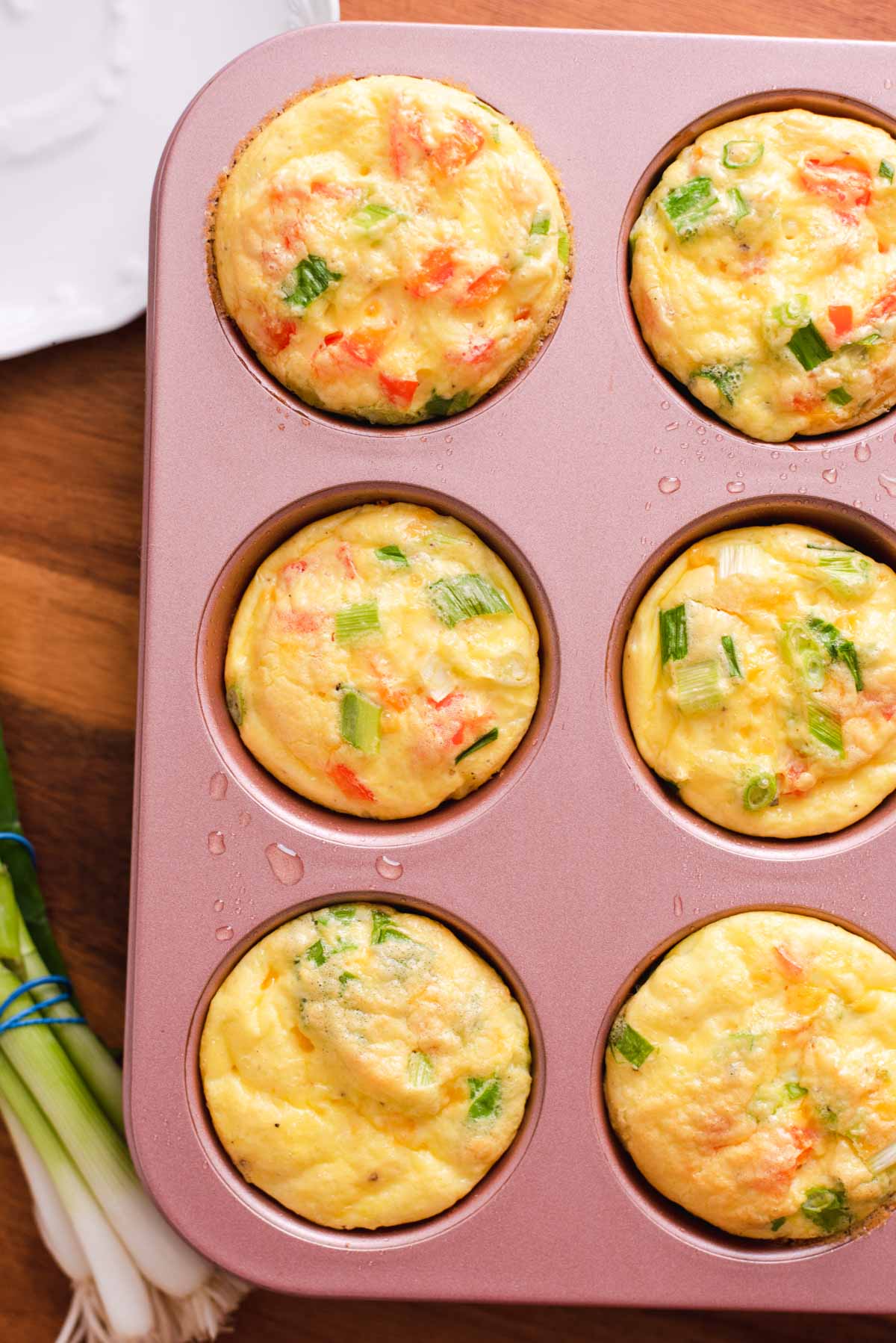 Overhead view of six egg muffins in a pink muffin tin