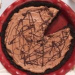 Overhead view of red pie dish filled with chocolate pie next to a plate with a slice of pie