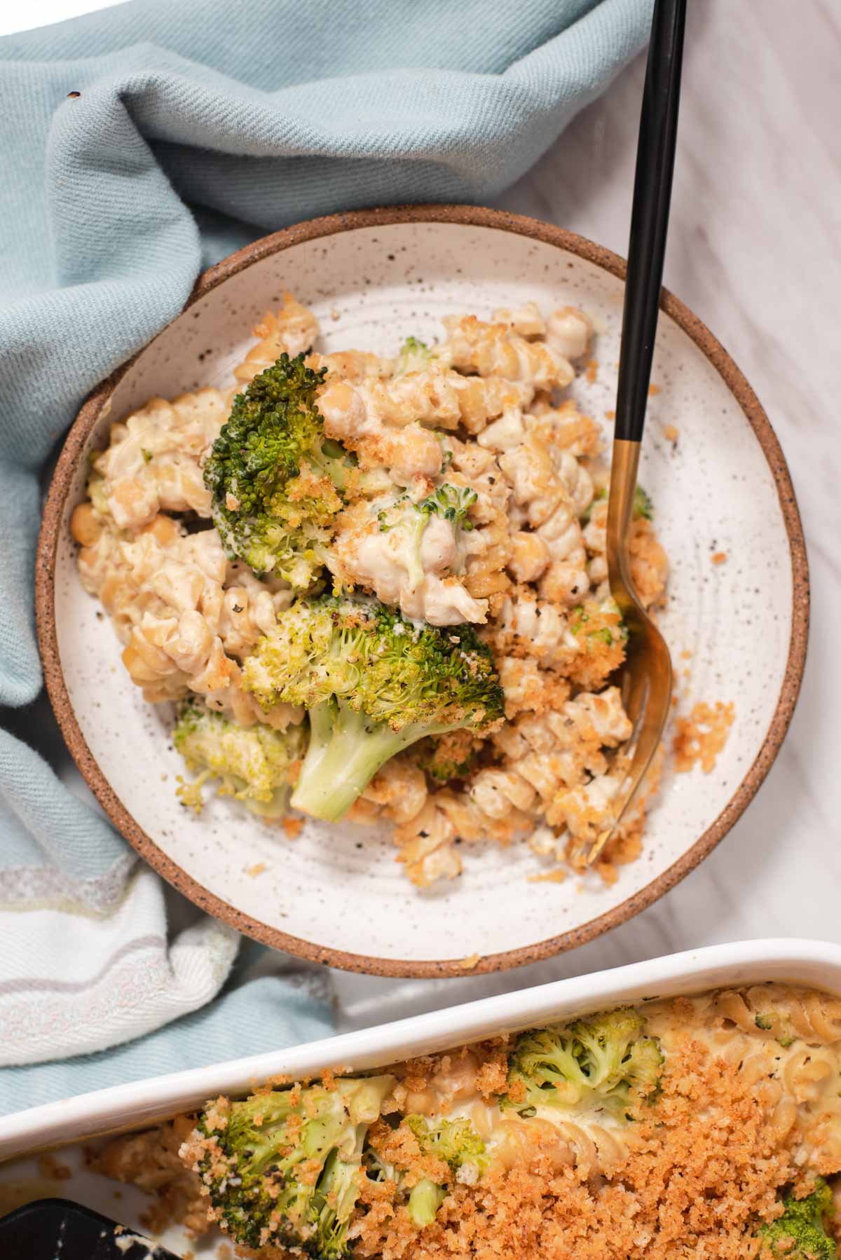 Overhead view of white bowl filled with pasta and broccoli.