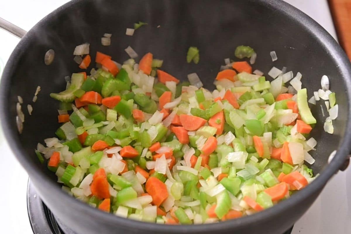 Onion, celery, carrot and bell pepper in a black Dutch oven.