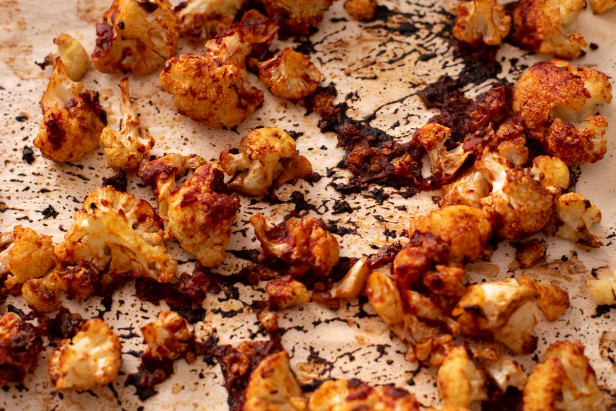 Close up of roasted cauliflower florets coated in browned chipotle sauce