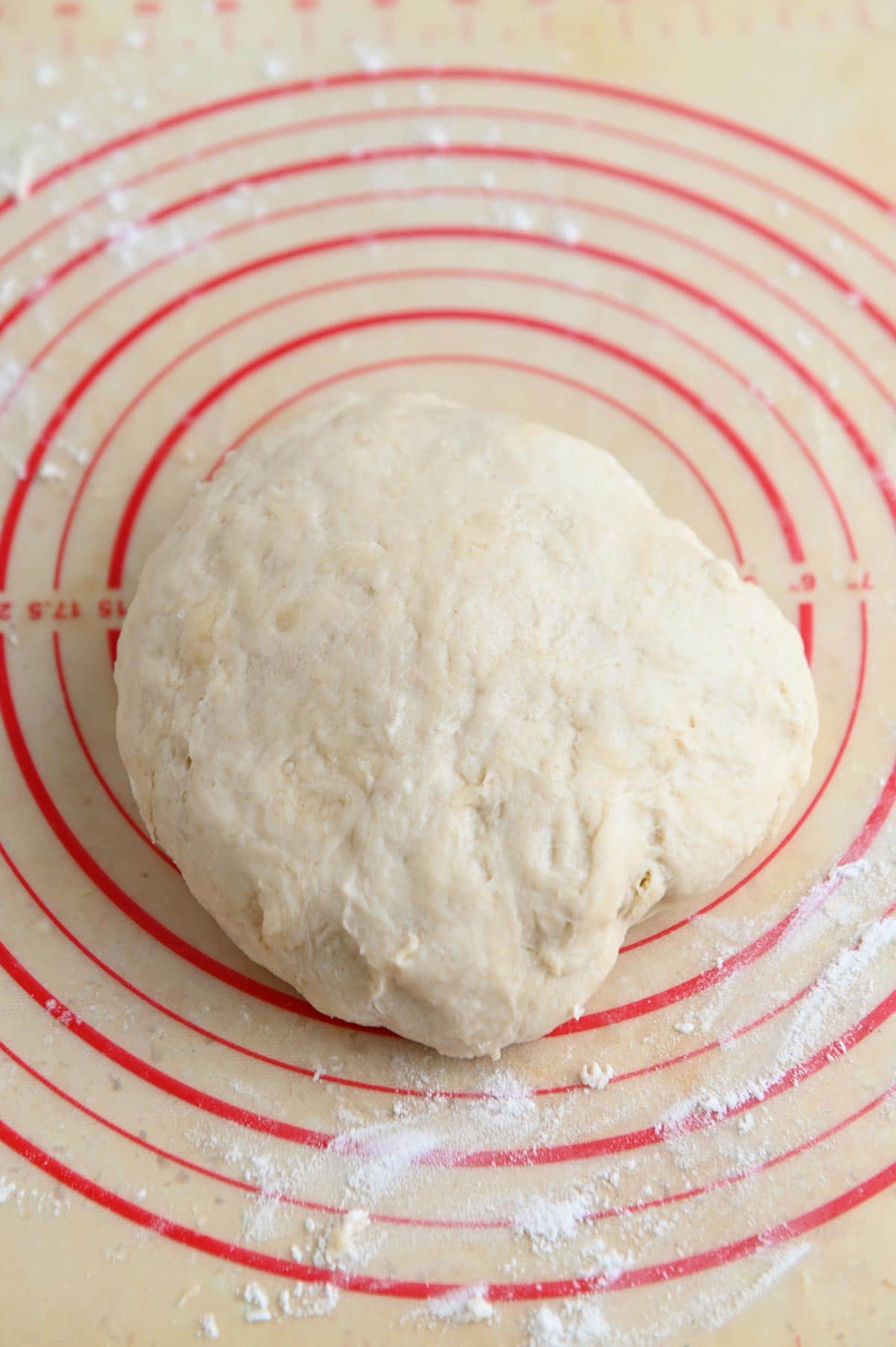 Smooth white ball of dough in the center of a surface with red circles