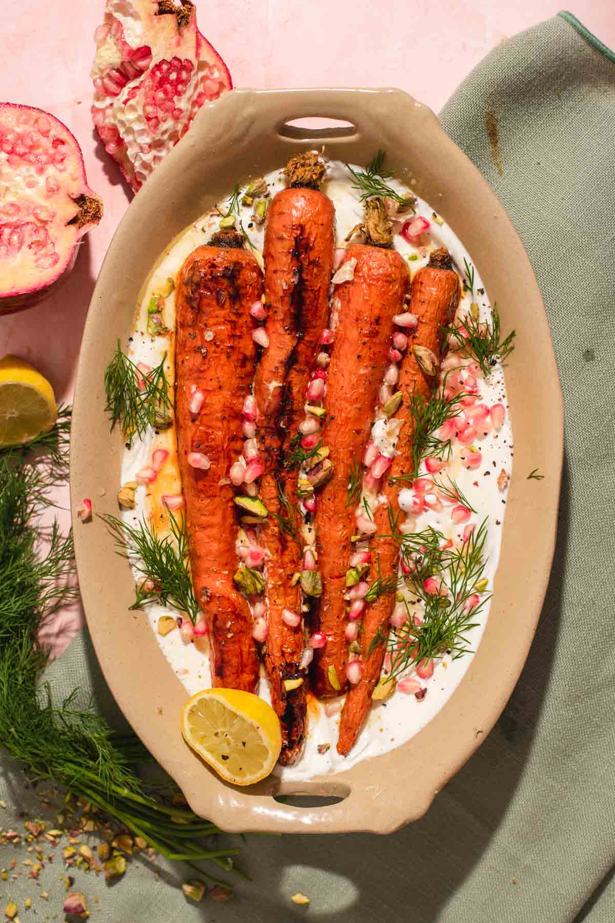 Four whole carrots on a bed of white whipped feta in a brown oval serving dish.