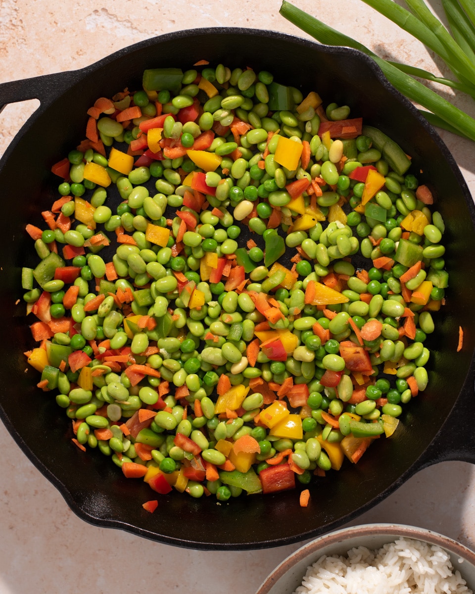 Cast iron skillet filled with peas, carrots, and edamame