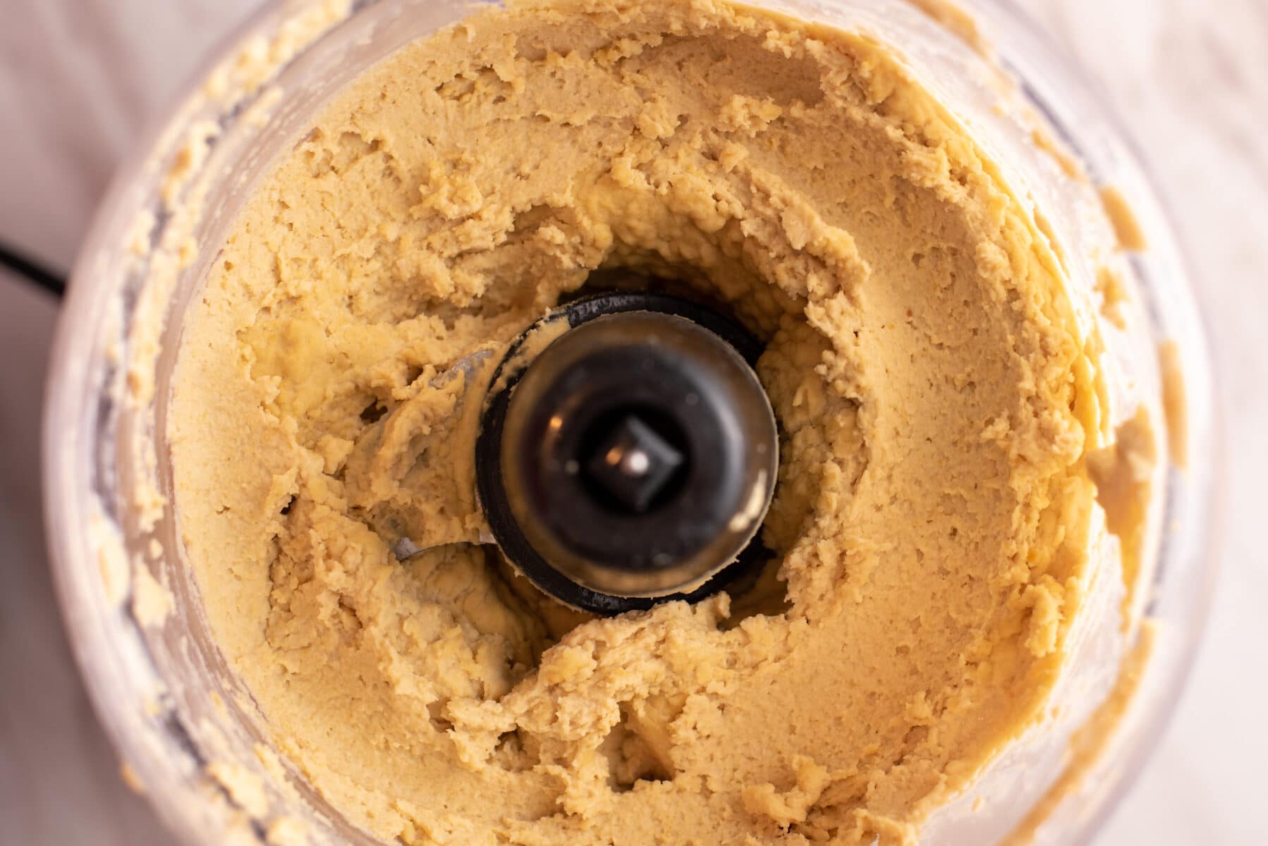 Close up of hummus in a food processor.