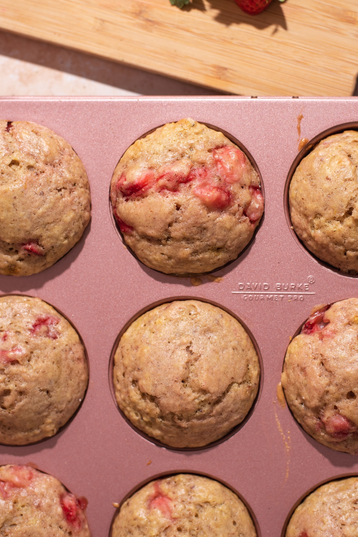 Overhead view of nine muffins in a pink pan.