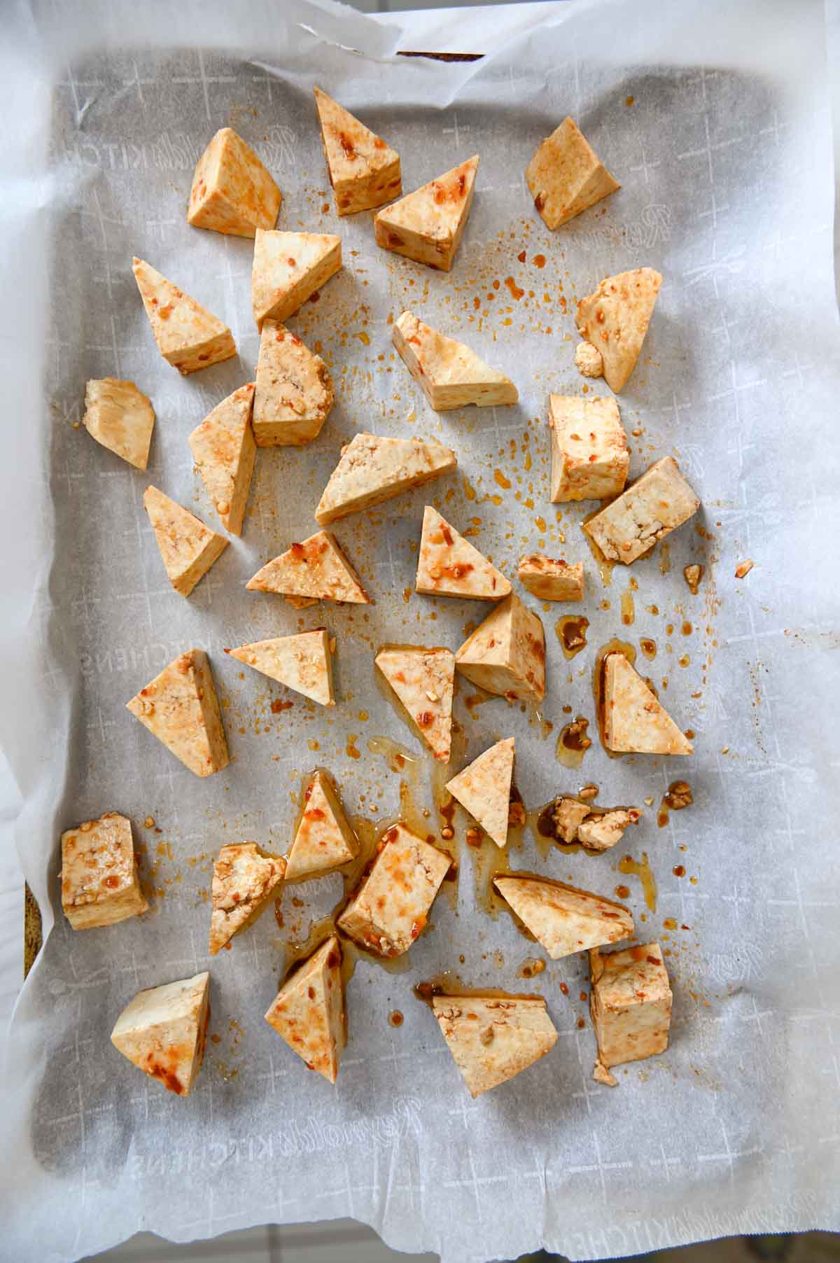 Tofu triangles on parchment paper.