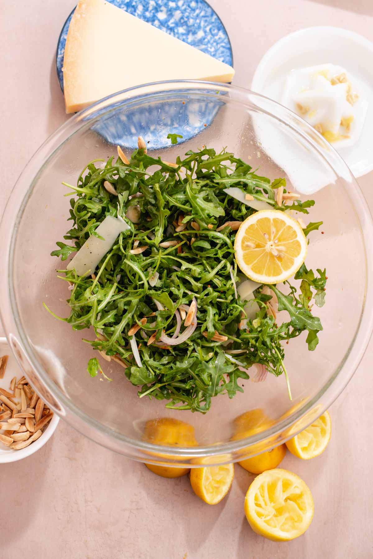 Overhead view of large glass bowl filled with arugula salad.