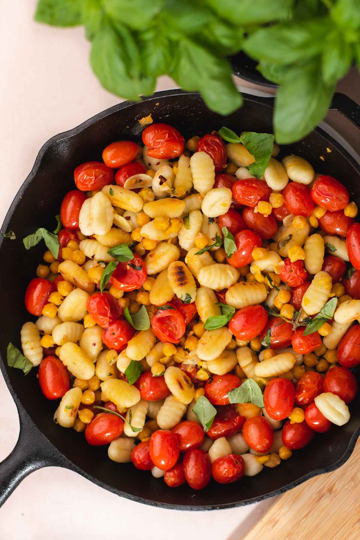 Overhead view of cast iron skillet with gnocchi and tomatoes.