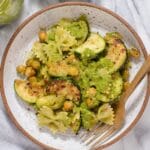 Overhead view of bowtie pasta with pesto, zucchini, and chickpeas.
