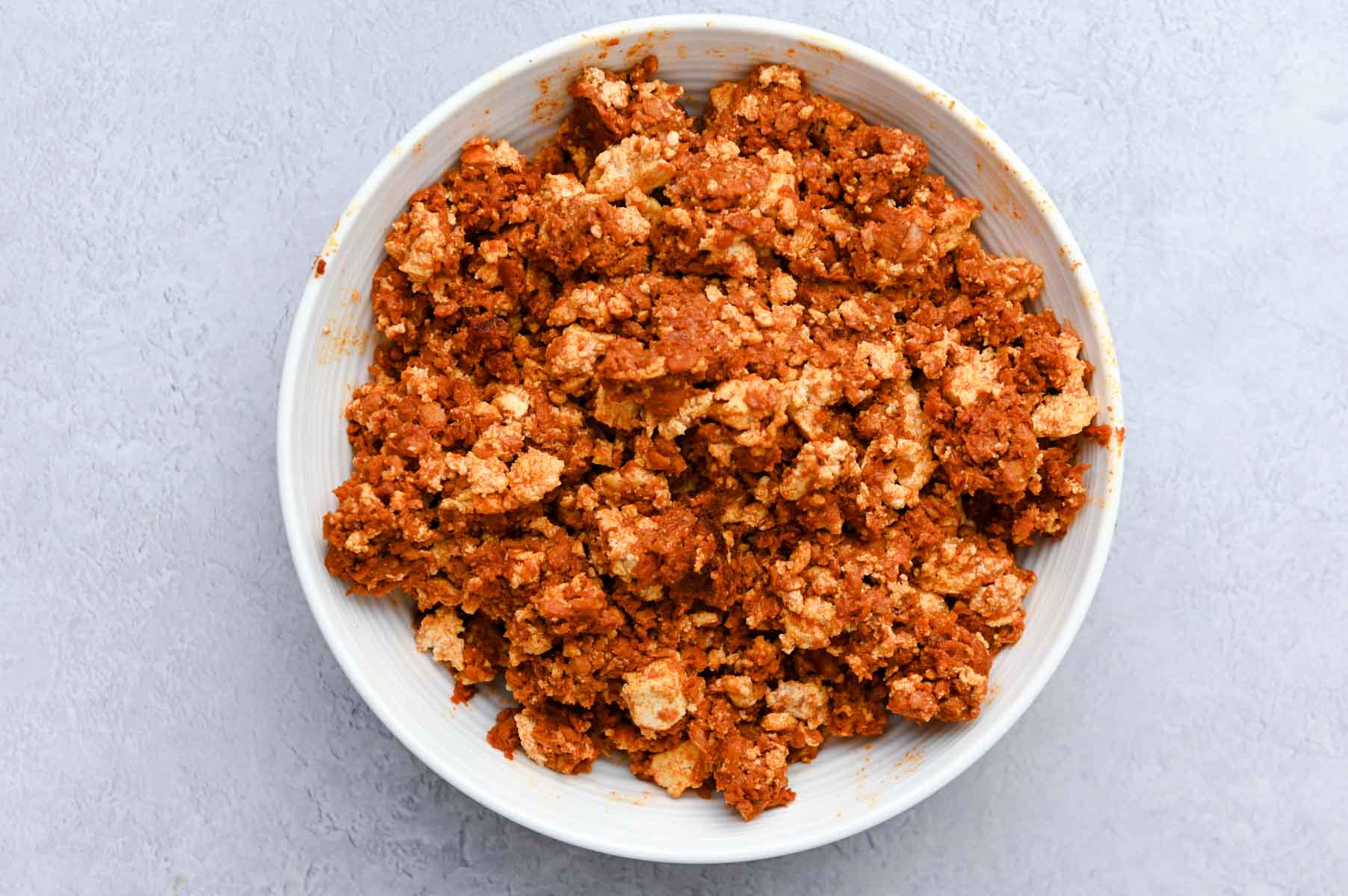 Soy chorizo and tofu in a white bowl.