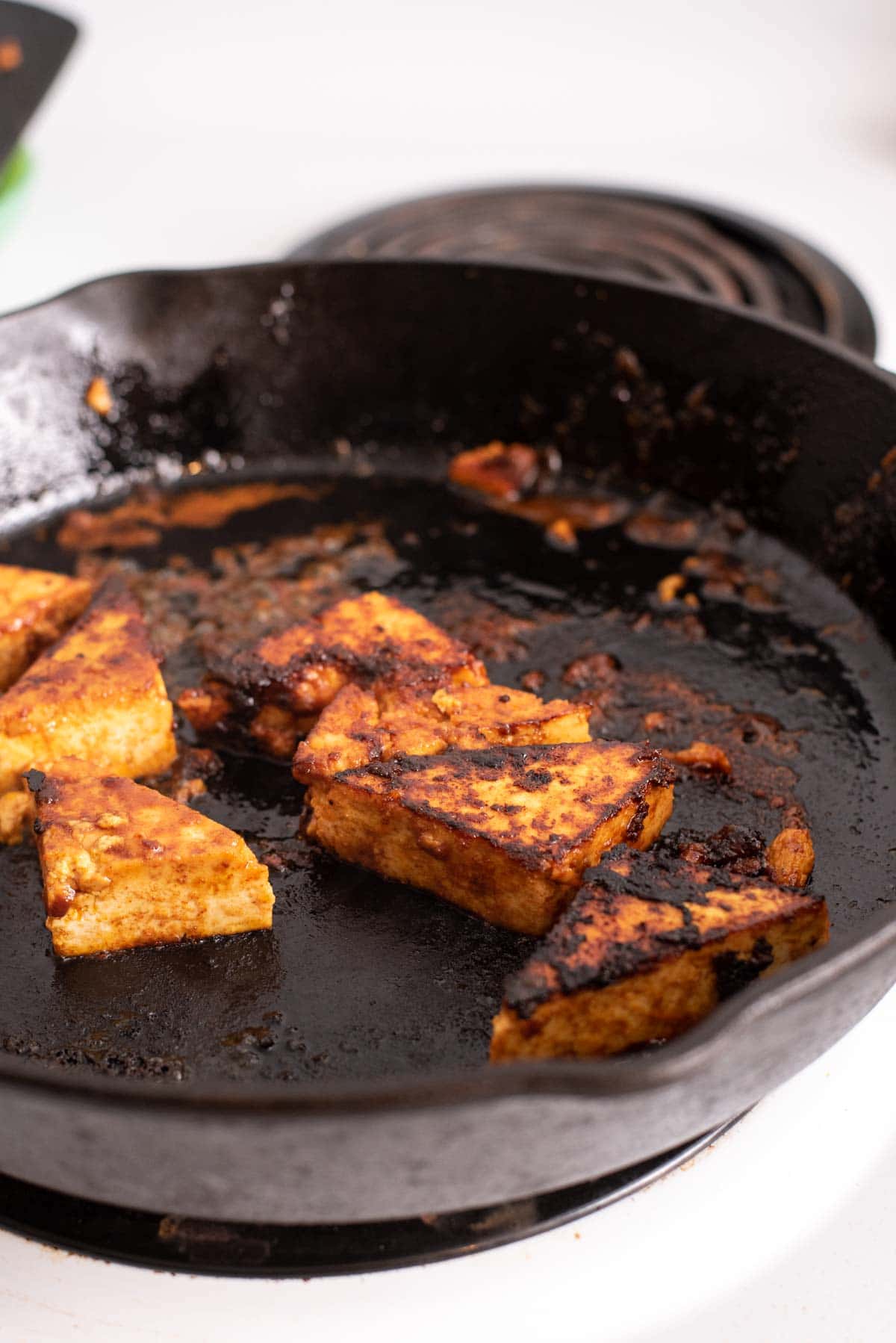 Charred tofu in a cast iron pan.