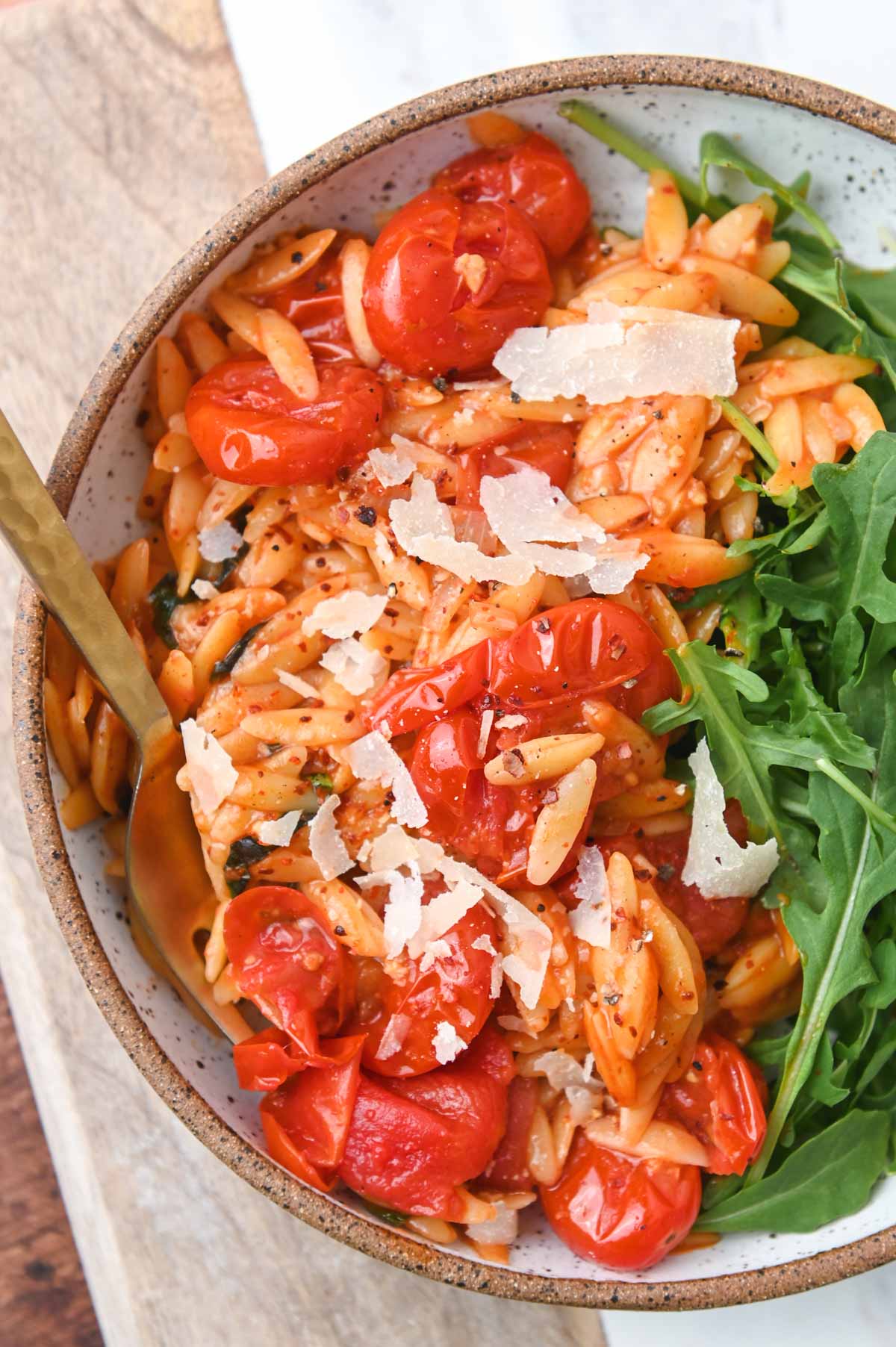 Close up of cherry tomato orzo in a bowl.