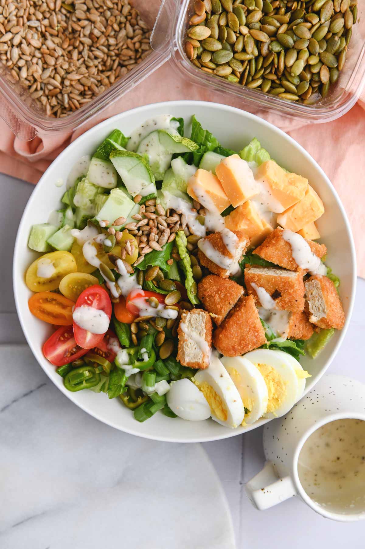 Overhead view of white bowl filled with salad ingredients. 