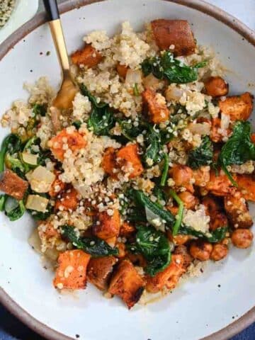 Chickpeas, sweet potato, and spinach in a bowl with quinoa.