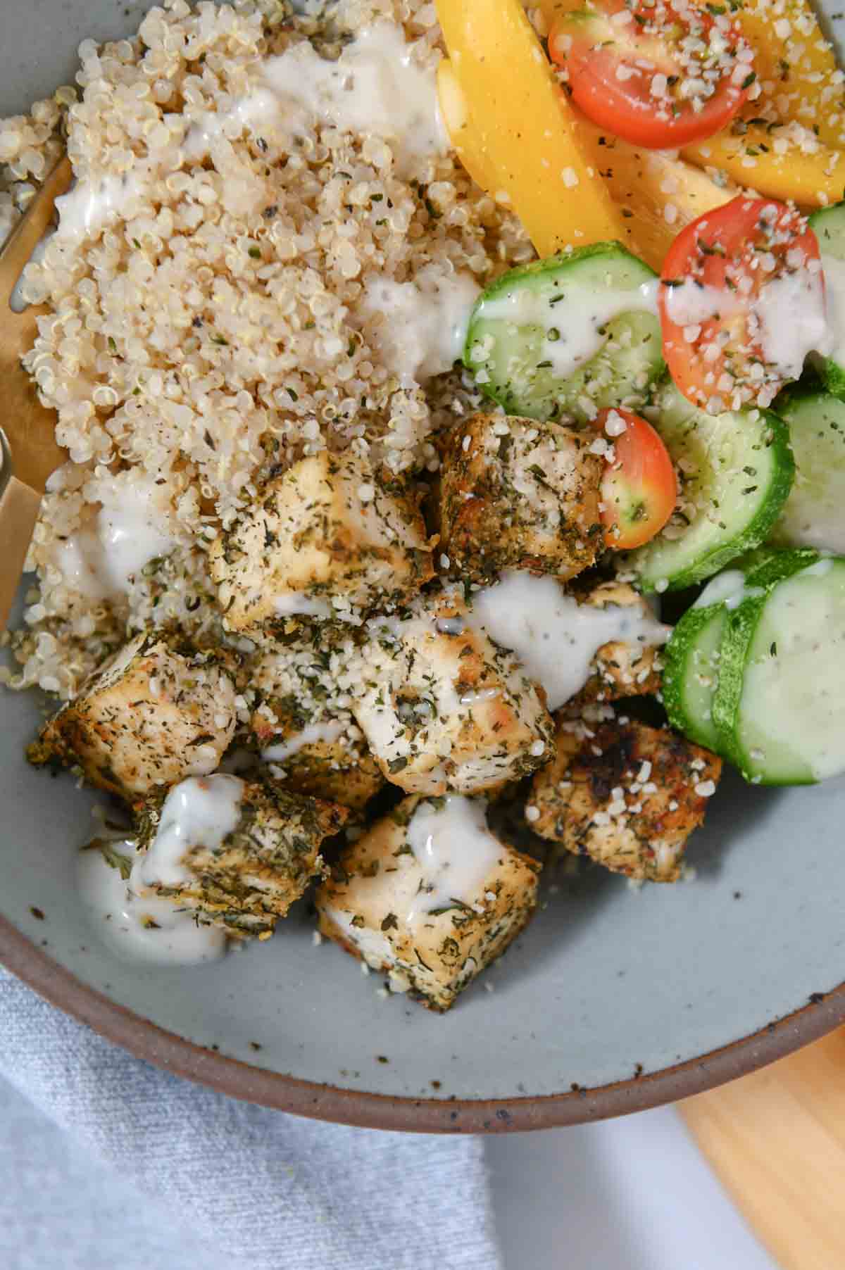 Tofu in bowl with quinoa and vegetables.