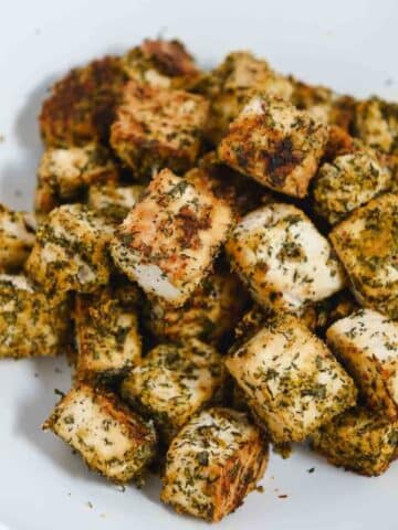 Close up of seasoned baked tofu in a white bowl.