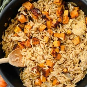 Overhead view of black skillet with orzo and butternut squash.