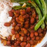 Close up of red beans and roasted green beans in a white bowl.