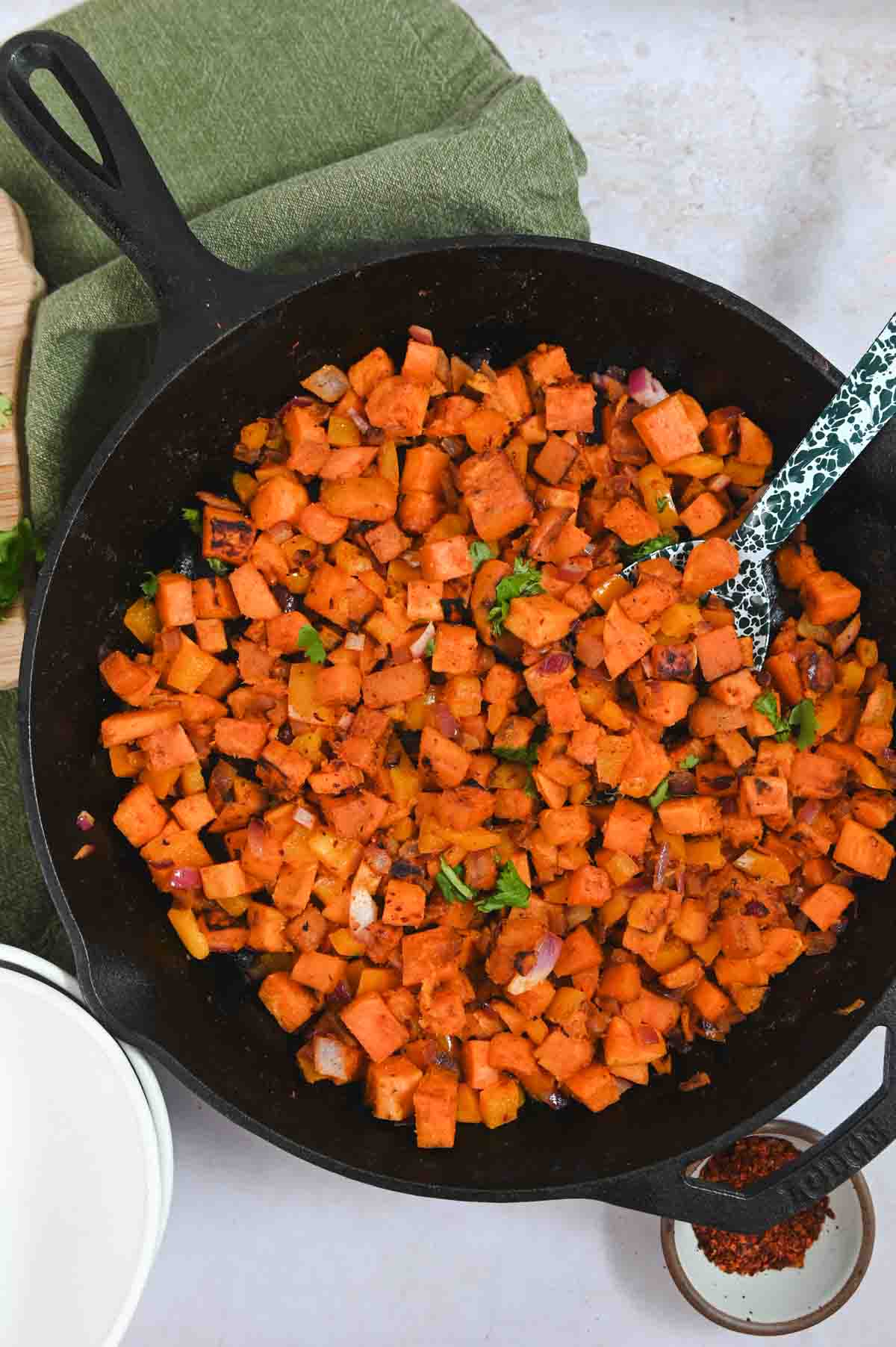 Overhead view of black cast iron skillet filled with sweet potato hash.