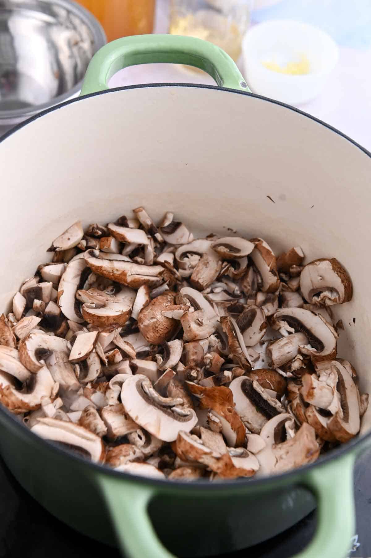 Raw sliced mushrooms in a pot before cooking.