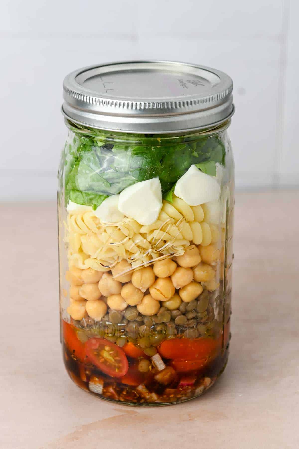 Quart sized mason jar filled with salad ingredients.