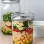 Glass jar with quinoa chickpea salad inside.